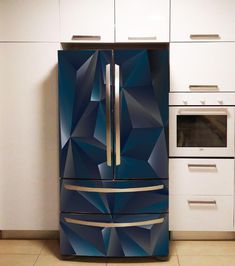 a blue refrigerator freezer sitting inside of a kitchen next to white cabinets and drawers