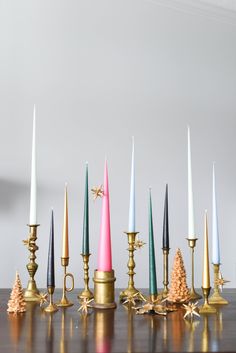 an assortment of candles sitting on top of a wooden table