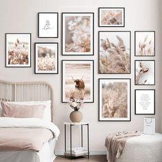 a bedroom with white walls and pictures on the wall above the bed, along with a small side table