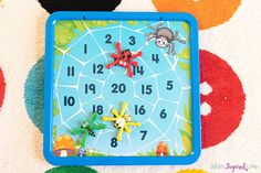 a blue clock sitting on top of a carpet covered in colorful dots and circles with cartoon animals