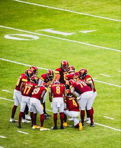 a group of football players huddle together on the field