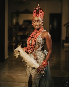 a woman in an elaborate dress holding a feather