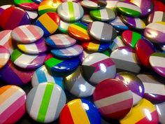 a pile of multicolored striped buttons sitting on top of each other in different colors