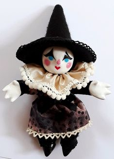 the doll is wearing a black hat and dress