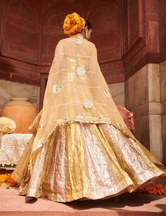 Shine bright in this exquisite silver and gold lehenga, featuring alternating lampi kalis that create a stunning visual impact. Paired with an intricately designed mirror work corset, this ensemble is beautifully complemented by a dupatta adorned with a mirror border. Perfect for festive occasions, this outfit effortlessly combines opulence and contemporary elegance, ensuring you stand out in any gathering. Mirror Border, Gold Lehenga, Cape Set, Beach Wedding Guests, Ritu Kumar, Jacket Cape, Indian Ethnic Wear, Mirror Work, Kaftan Dress