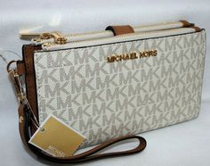 BRAND NEW with TAGS!  MICHAEL KORS  Jet Set Travel Double Zipped Wristlet LATEST FASHION VERY UNIQUE   100 % GUARANTEED AUTHENTIC or your money back !   7.25"L x 4.5"H x 1.5"W MK signature PVC and leather  MK gold Logo plaque on front  Water & stain resistant Polished gold hardware One phone case ( I phone 7 ) slot with button closure Double zipped closure with secure button closure 6 credit card slots, 1 ID window 12" long wristlet strap Original Michael Kors price tag   All items come from cle Hip Purse, Mk Wallet, Trendy Purses, Bag Obsession, Girly Bags, Wallet Wristlet, Handbags Women, Michael Kors Wallet, Cute Purses