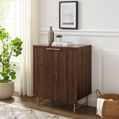 a wooden cabinet in a living room next to a potted plant