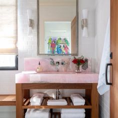 a bathroom with pink counter top and wooden cabinet