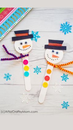 two snowmen made out of popsicle sticks