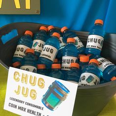 there are many bottles of blue liquid in the bowl on the table next to a sign that says chug jug