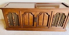 a large wooden cabinet sitting on top of a carpeted floor