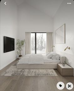 a large white bed sitting in a bedroom next to a tv mounted on a wall