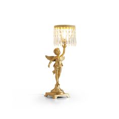 a golden angel holding a crystal ball on top of a table lamp with a white background