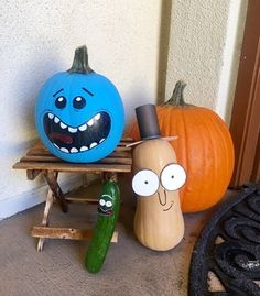 two pumpkins with faces painted on them sit next to each other in front of a door