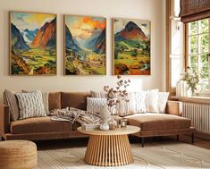 a living room with two paintings on the wall and a coffee table in front of it