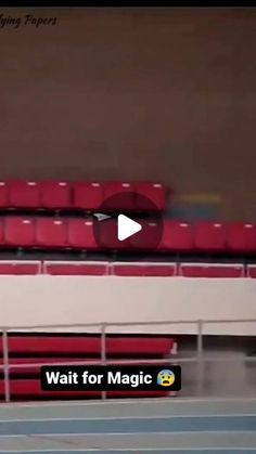 a tennis player is swinging his racket at the ball in front of red seats