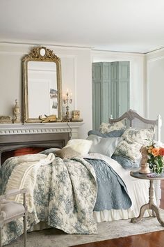 a bedroom with a bed, mirror and fireplace