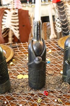 three medieval style wine bottles sitting on top of a table next to plates and candles