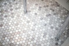 a bathroom with hexagonal tiles on the floor