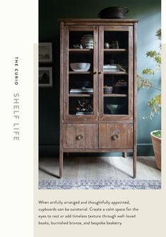 an old wooden cabinet with glass doors in the center and dishes on it's shelves