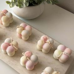 several small candies tied with twine on a marble board next to a potted plant