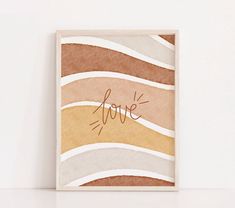 a card with the word love written in cursive writing on it next to a white wall