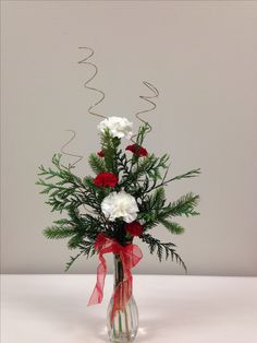 a vase filled with white and red flowers