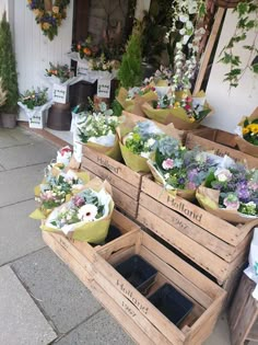 several wooden boxes filled with different types of flowers