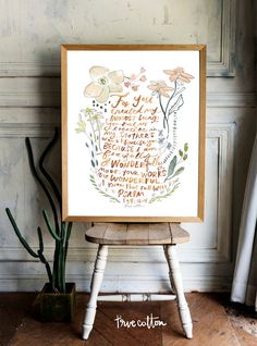 an art print on a wooden chair next to a potted plant