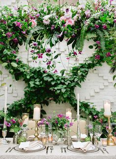 the table is set with candles, plates and place settings for an elegant dinner party