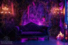 a couch sitting in front of a purple wall with candles