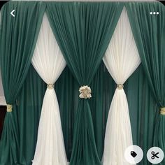 the curtains are green and white with gold trimmings on each side, along with a flower in between them