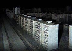 an old building in the middle of a city at night with lots of windows and balconies