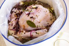 a close up of a chicken in a bag with herbs and seasonings on it