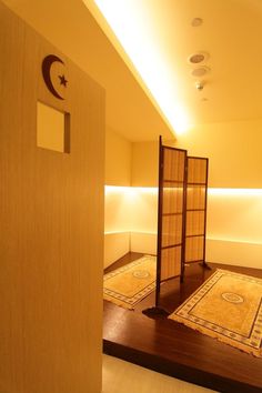 an empty room with wooden partitions and rugs on the floor