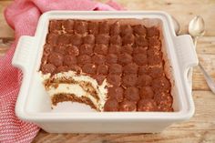 a cake in a white dish on top of a red and white checkered table cloth