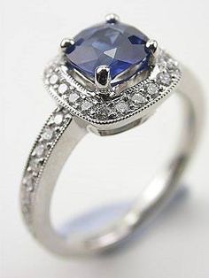 an engagement ring with a blue stone surrounded by diamonds