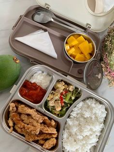 a bento box filled with rice, fruit and vegetables next to a green pear