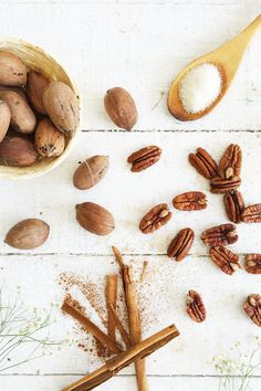 nuts and cinnamon sticks on a white wooden table