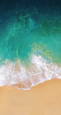 an aerial view of the ocean and beach with waves crashing on it's shore