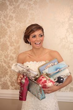 a woman in a wedding dress holding many purses