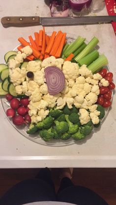 a plate with vegetables and carrots in the shape of a face