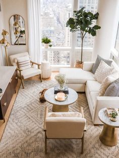 a living room filled with furniture and a large window overlooking the cityscape in new york