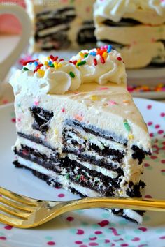 a slice of cake on a white plate with sprinkles and a fork