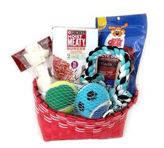 a basket filled with dog toys and treats on top of a white table next to a red bag