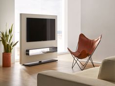 a living room with a large flat screen tv on the wall next to a chair