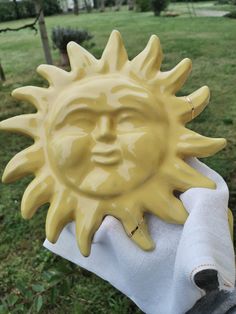 a yellow sun statue sitting on top of a white towel