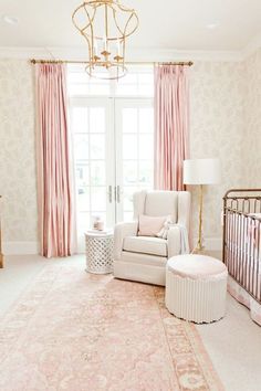 a baby's room is decorated in pink and white with an ornate chandelier