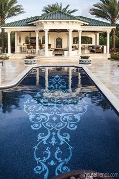 the pool is surrounded by palm trees and has an intricately designed design on it