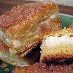 two pieces of bread sitting on top of a green plate covered in powdered sugar